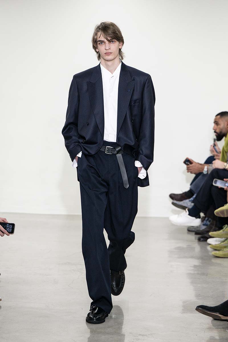 Donkerblauw herenpak van Paul Smith met wit overhemd met Koreaans kraagje en geknoopte leren riem. Photo Paul Smith
